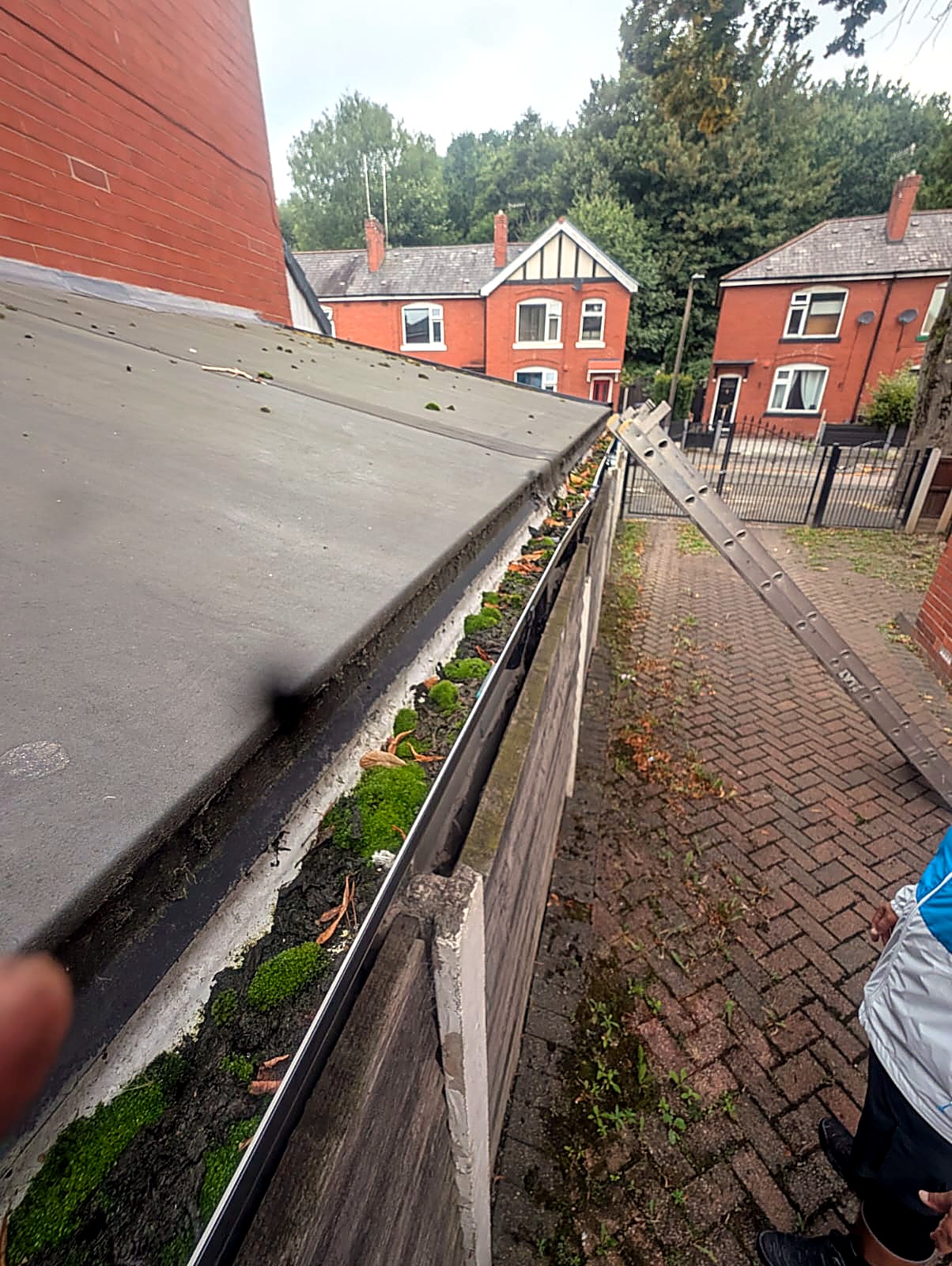 Gutter filled with roof grit and silt before gutter cleaning in Bolton, Greater Manchester